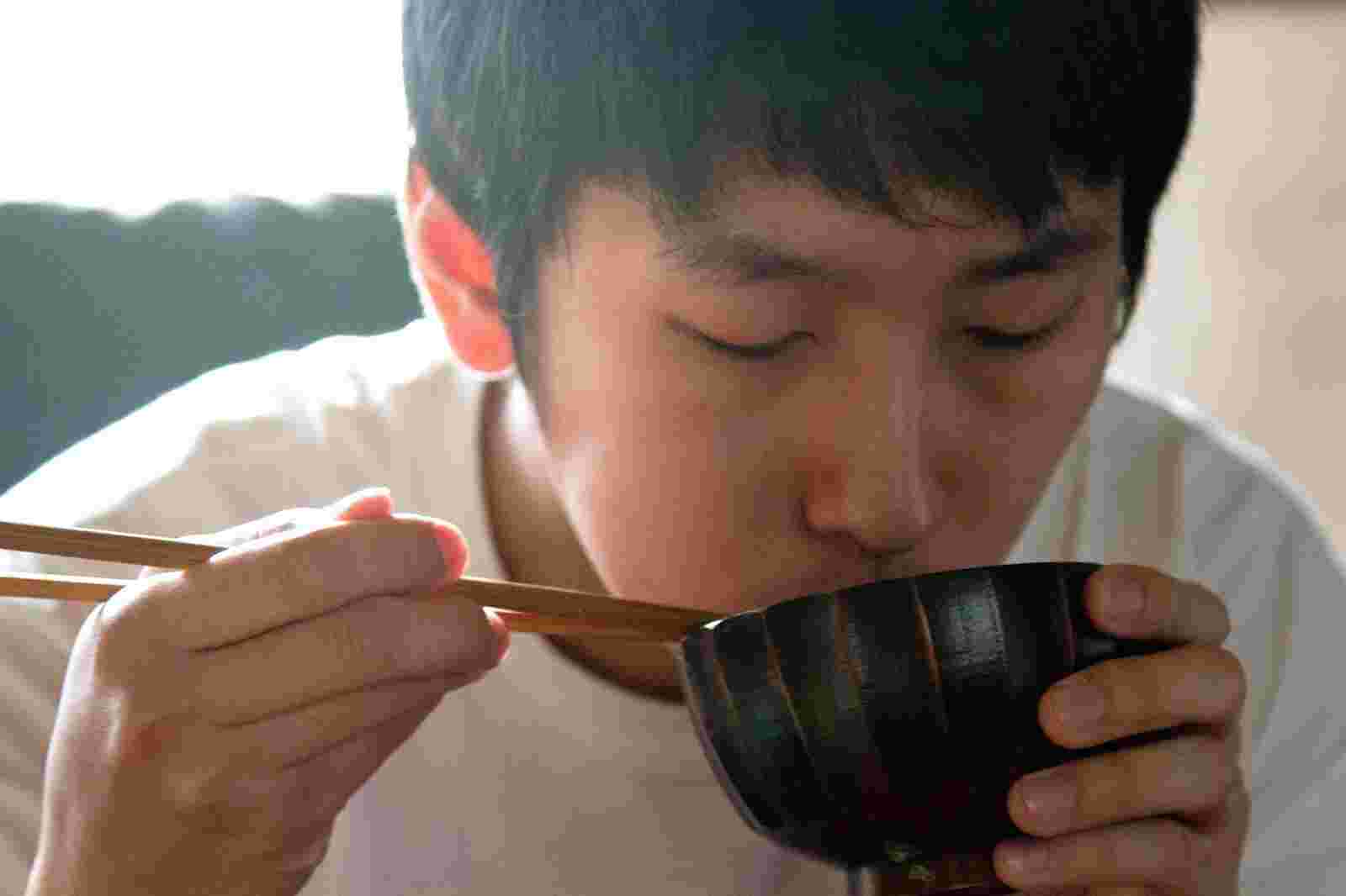 スープを飲む男性