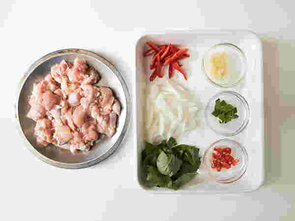 鶏肉が入っているボールとバットに並べたガパオライスの材料