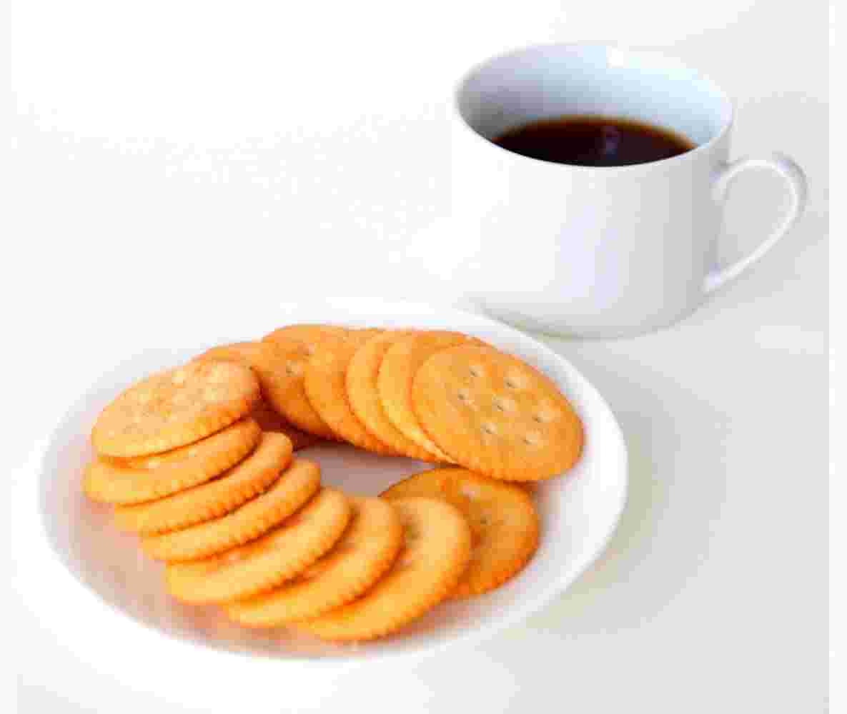 リッツクラッカーを白い皿に並べてコーヒーを添える