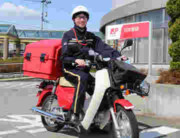 バイクで郵便を配達しているおじさん