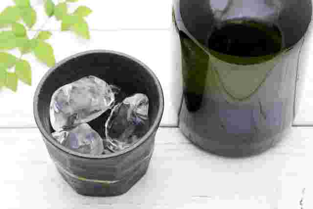 グラスに注がれた焼酎と焼酎の瓶