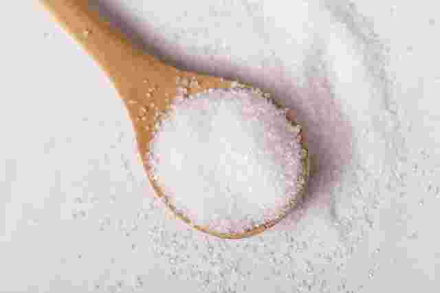 スプーンいっぱいに盛られた砂糖の画像