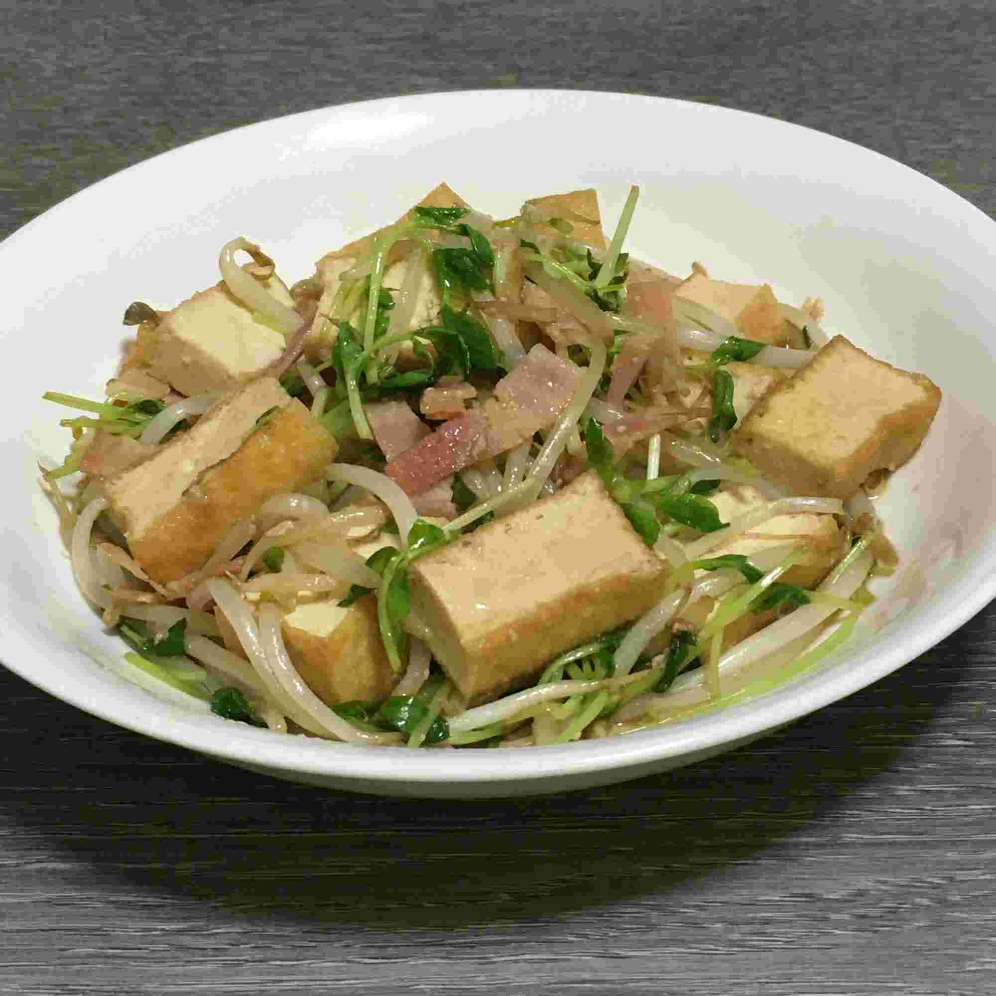 厚揚げとベーコンの炒め物が白いお皿に盛られている様子