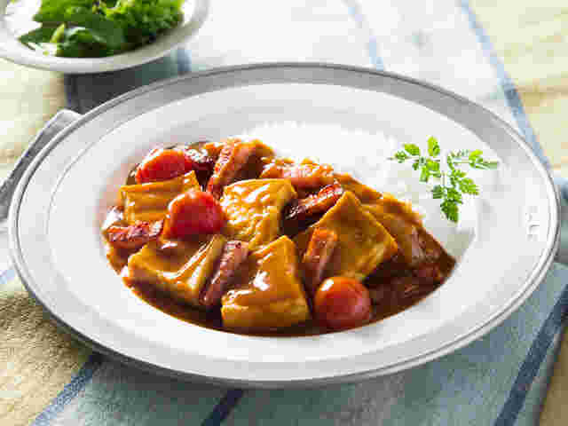 厚揚げとベーコンのカレーがカレー皿に盛り付けられている様子
