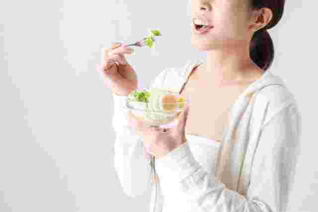 キャベツとレタスを食べる女性
