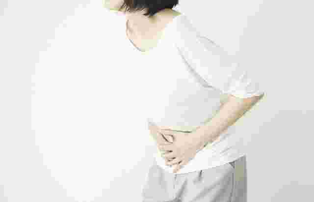 お腹をおさえる女性