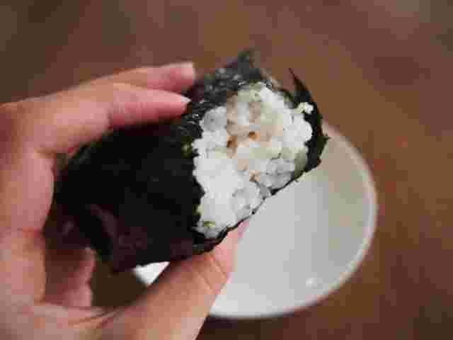 食べかけのおにぎりを持った手