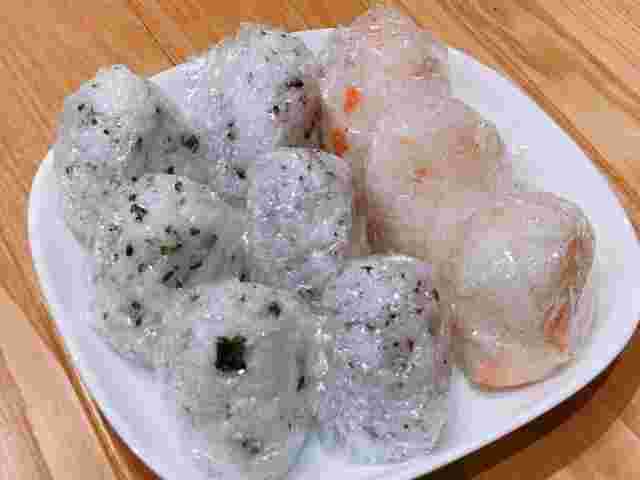 ラップに包まれて皿に乗った数種類のおにぎり