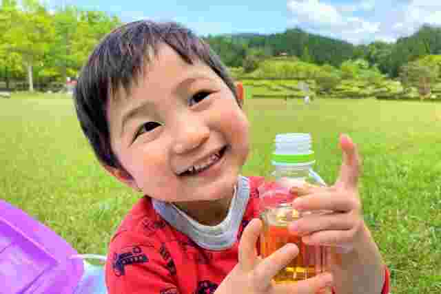 ペットボトルのお茶を持つ子供