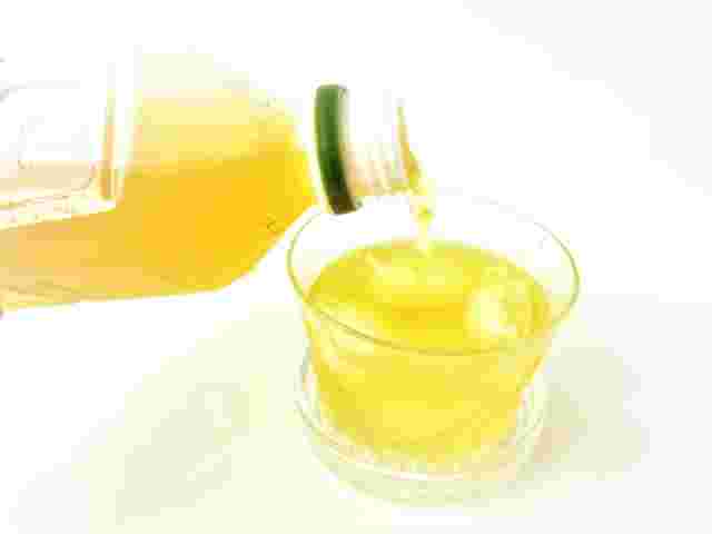 ペットボトルのお茶をコップに注いでいる画像