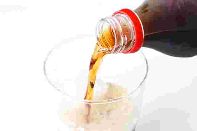 ペットボトルからコップに注がれる炭酸飲料