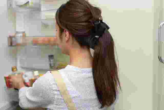 冷蔵庫に調味料を入れる女性