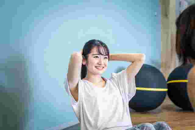 笑顔で腹筋する女性