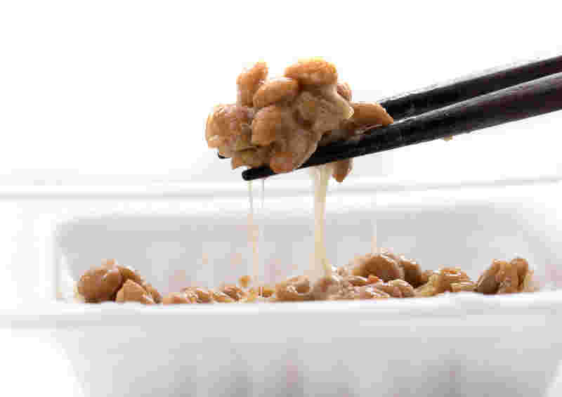 パックに入った納豆をつかむ箸