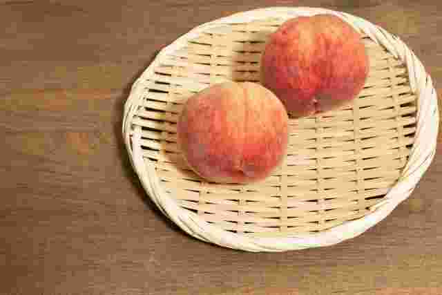 かごに乗った2個の美味しい桃