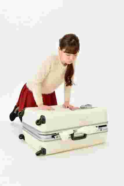 トランクに荷物を詰め込む女性