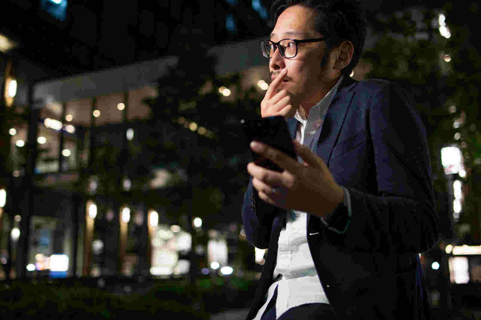 スマホを持って悩む男性