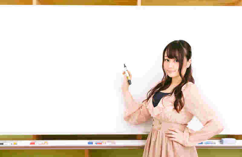 ホワイトボードの前に立つ女性