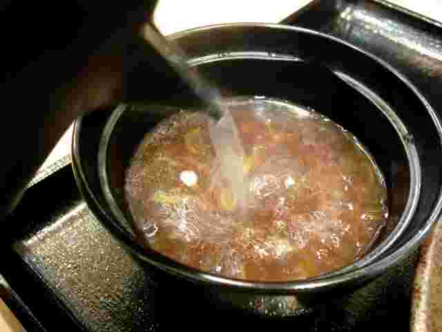 そばつゆにそば湯を注いでいる様子
