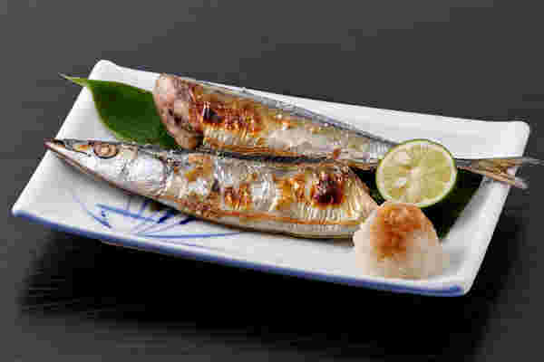 焼かれたサンマが半分に切られてお皿に盛られている