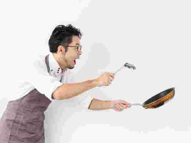 フライパンを持って慌てている男性