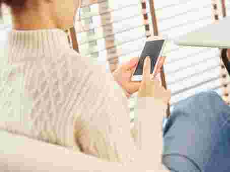 スマホを使って調べものをする女性