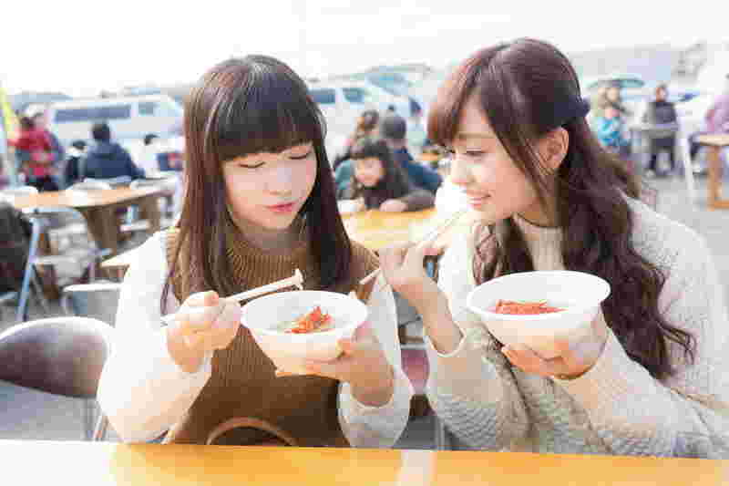 野外で何かを食べている女性