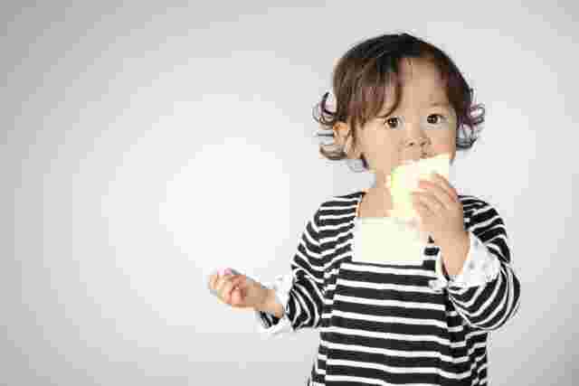 食パンを頬張る幼児