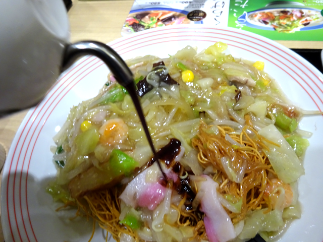 皿うどんにソースをかけている様子