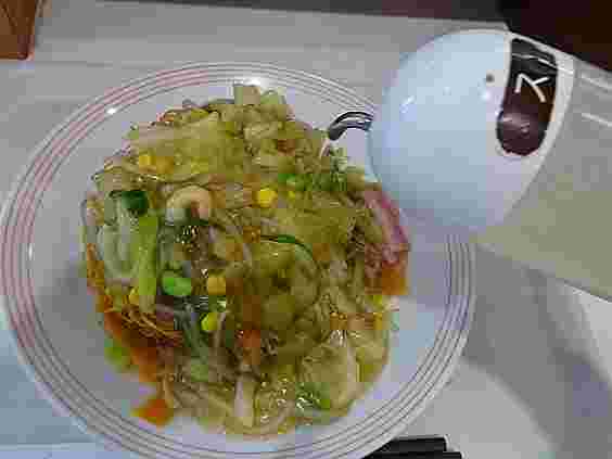 皿うどんにお酢をかけている様子