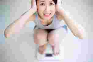 体重計に乗って、自分の体重が直視できない女性