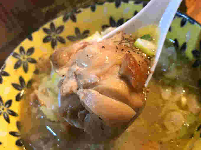 鳥煮込みの鶏肉をレンゲに掬った様子