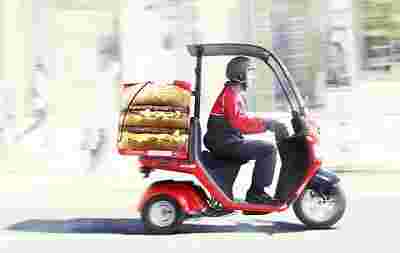 マクドナルドの宅配サービスでバイクに乗るスタッフ