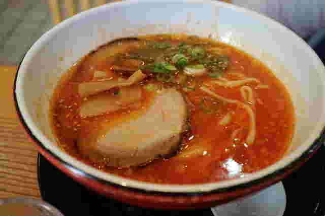 赤いトマトベースのスープのラーメン