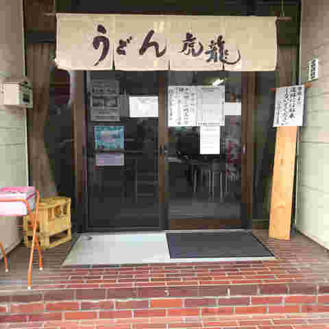 暖簾にはうどん虎龍と大きく書かれている玄関