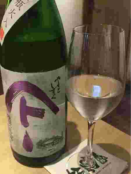 日本酒瓶とワイングラスに注がれた日本酒