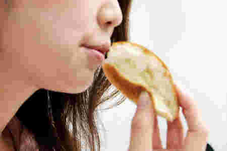 フランスパンを食べる女性