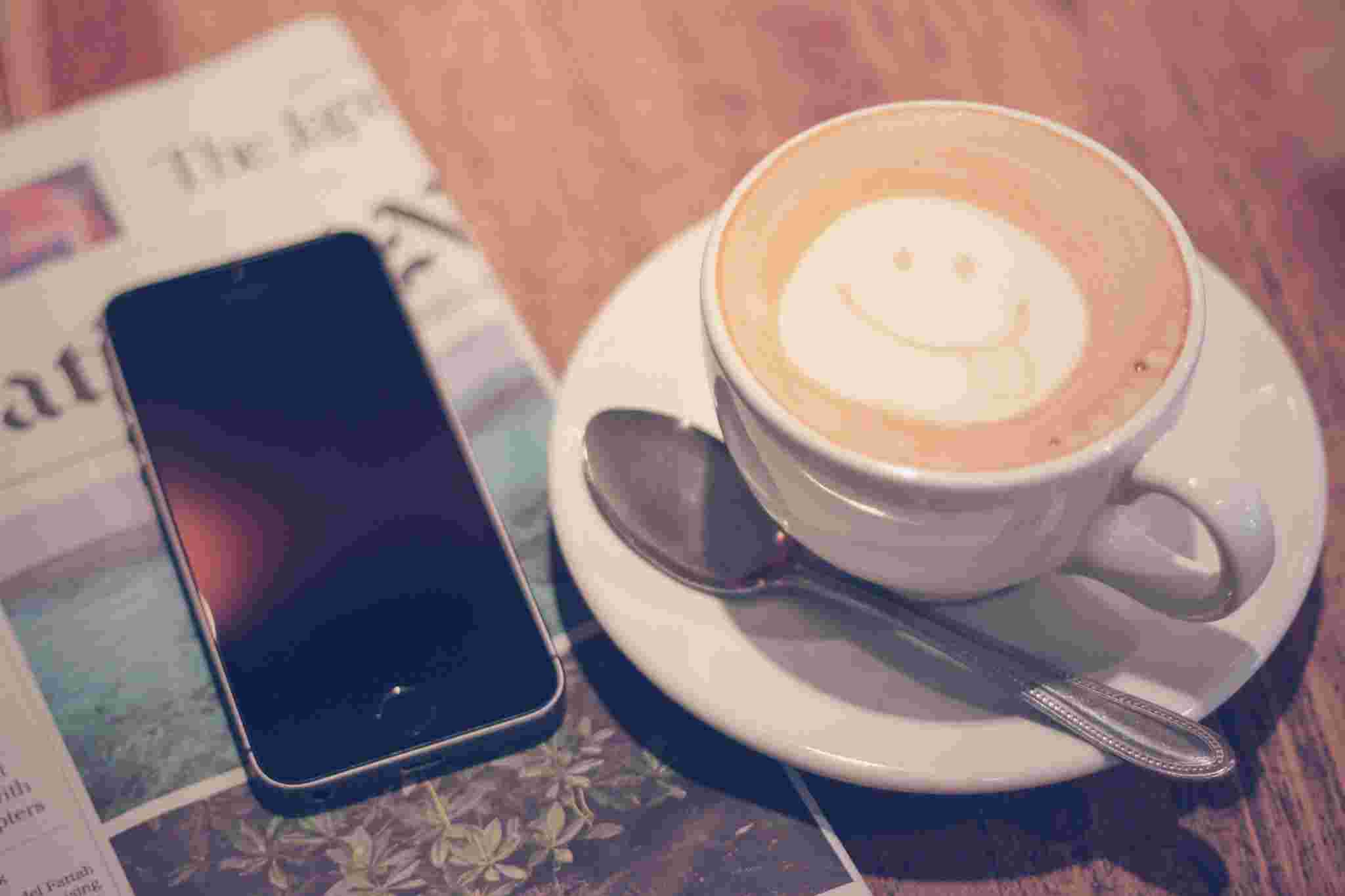 スマホとカフェラテの写真