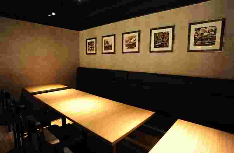 テーブル席と壁に額縁がいくつか飾られている店内