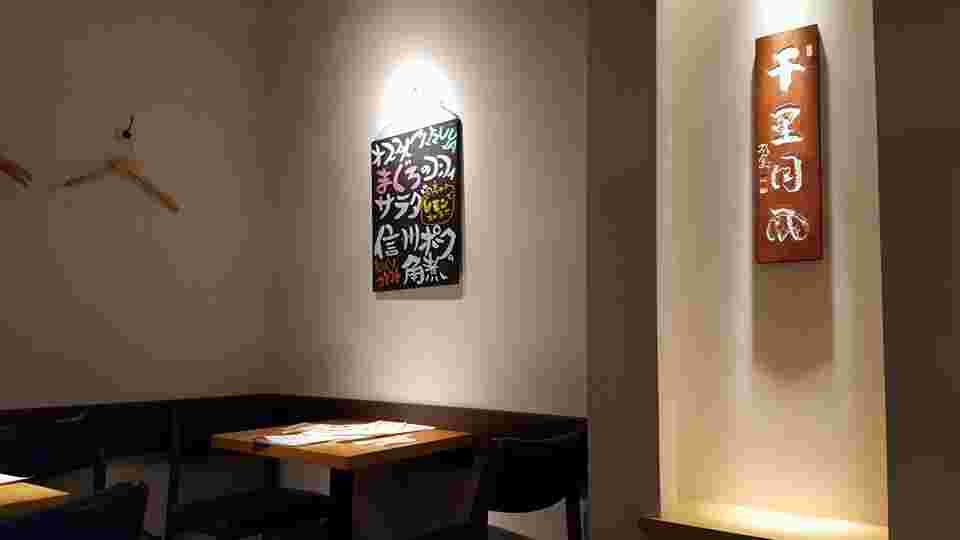 壁にハンガーとボードが飾ってあるテーブル席の店内