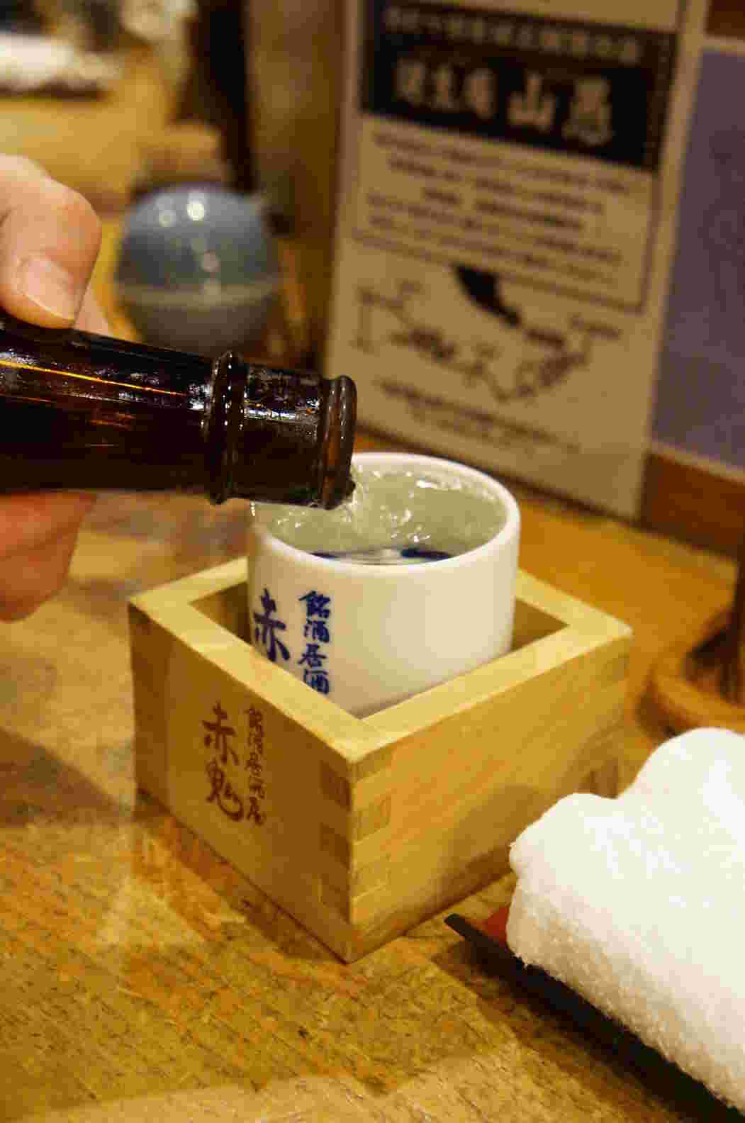 赤尾にとかかれた枡にはいってる酒