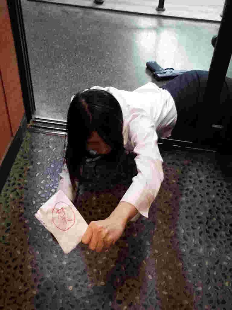 秘密文書を持って倒れるスパイ役のスタッフ