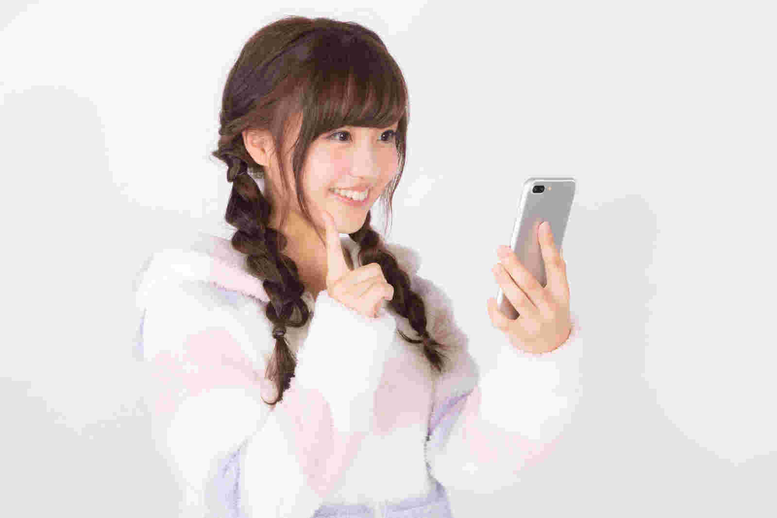 スマホでクーポンが見つかって嬉しそうな女性