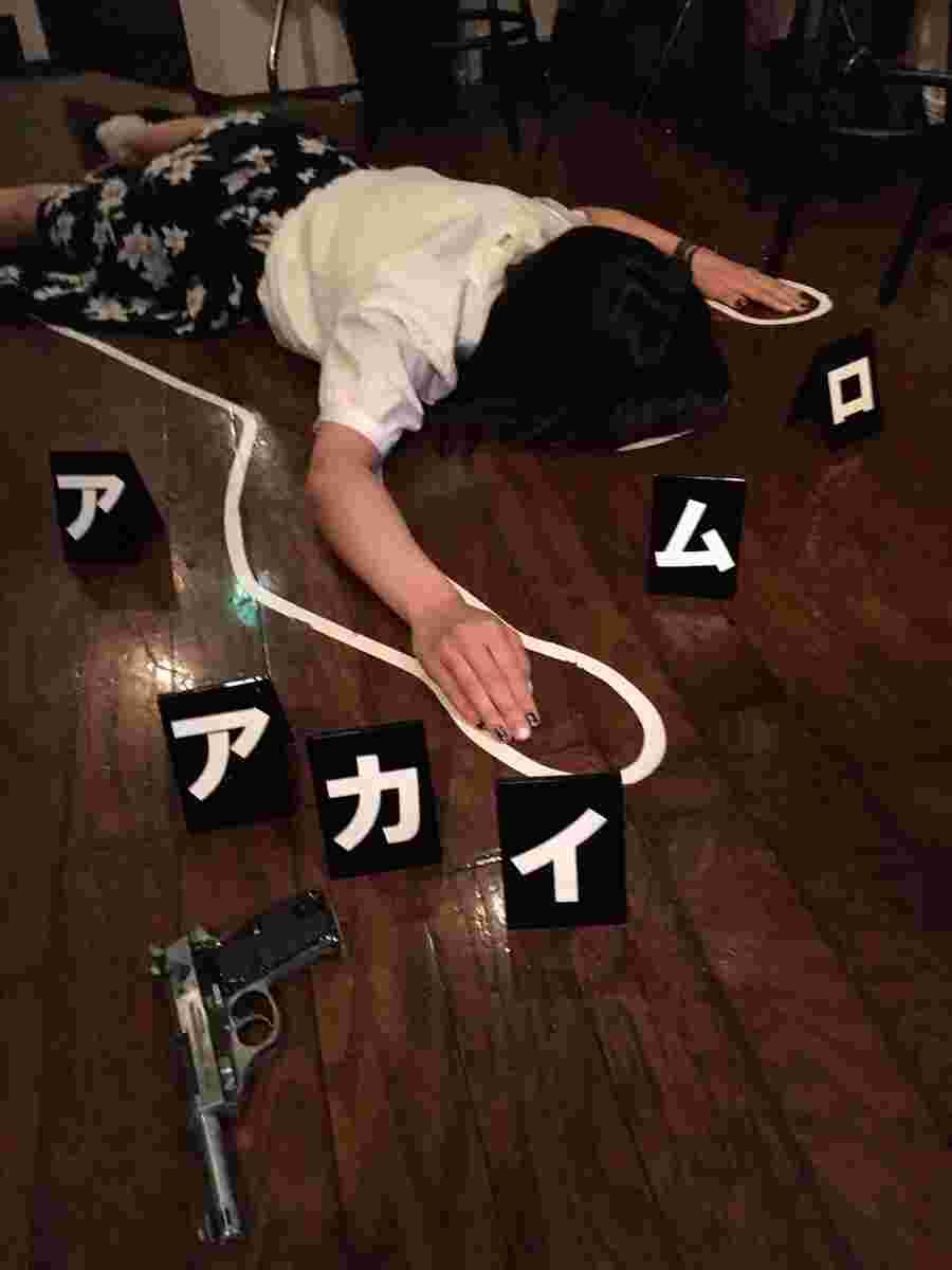 床に横たわる死体のふりをする女性