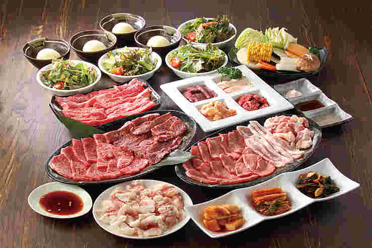 様々な種類の美味しそうなお肉やサラダ、デザートが並んだ画像