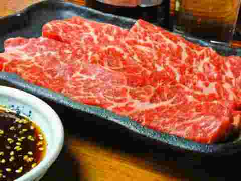 焼肉のタレと美味しそうなさしの入った牛肉の画像