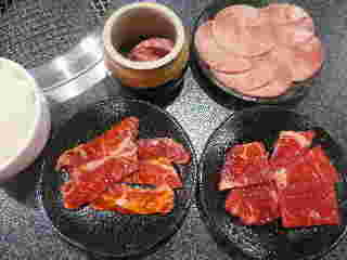 タレのかかった美味しそうな牛肉と綺麗にスライスされた牛タンの画像