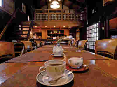テーブルの上にコーヒー、木の温もりを感じる店内