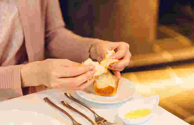 フランスパンを食べる女性