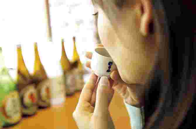 ぐい呑みで試飲する女性